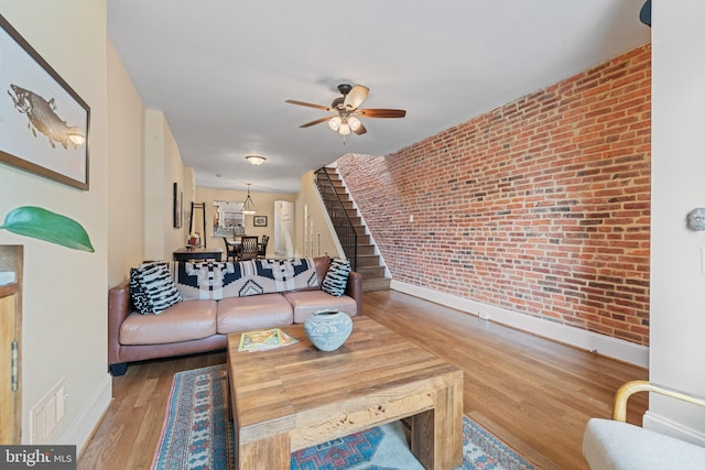 3004 E Pratt St, Baltimore, MD 21224 - living area featuring brick wall, ceiling fan, and wood finished floors