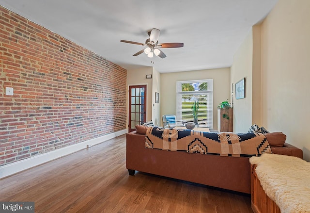 3004 E Pratt St, Baltimore, MD 21224 - living area featuring brick wall, wood finished floors, and ceiling fan