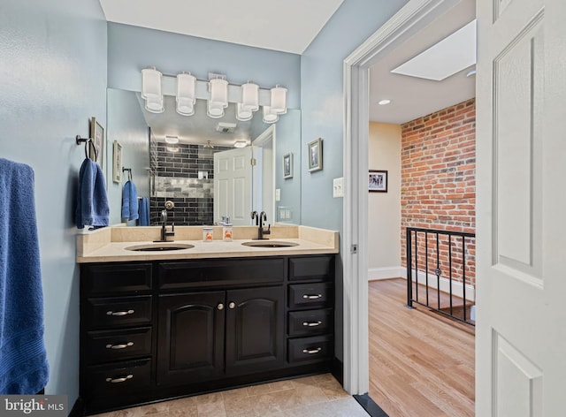 3004 E Pratt St, Baltimore, MD 21224 - bathroom featuring double vanity, tiled shower, and wood finished floors