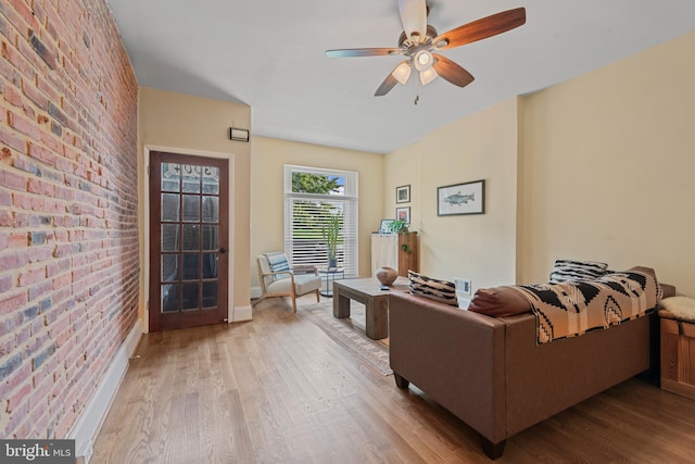 3004 E Pratt St, Baltimore, MD 21224 - living area with brick wall, wood finished floors, and a ceiling fan