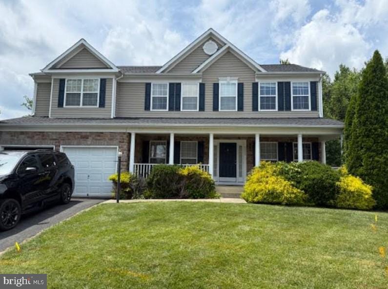 5473 Loggerhead Pl, Woodbridge, VA 22193 - colonial home featuring a front yard, covered porch, a garage, and asphalt driveway