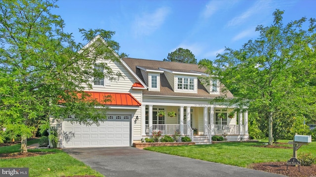 1 Lake Village Cir, Ocean View, DE 19970 - view of front of house with a porch, driveway, an attached garage, a front yard, and a standing seam roof