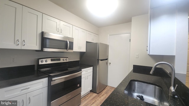 7705 Lafayette Forest Dr Unit 77, Annandale, VA 22003 - kitchen with appliances with stainless steel finishes, light wood-style flooring, white cabinets, and dark stone countertops