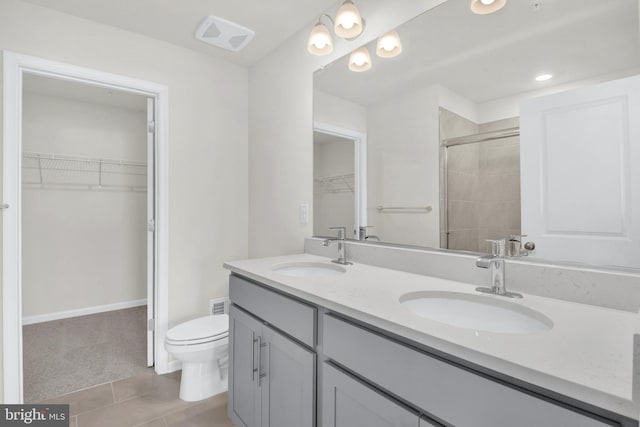 338 Ensemble Way, Frederick, MD 21701 - bathroom with double vanity, a walk in closet, toilet, tiled shower, and tile patterned floors