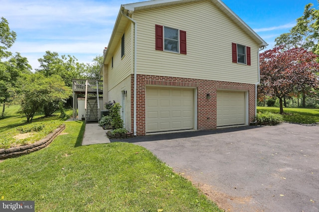 129 Deck Rd, Womelsdorf, PA 19567 - view of home's exterior featuring asphalt driveway, an attached garage, a yard, and brick siding