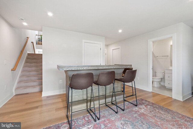 8790 Kensington Church St, Manassas, VA 20112 - kitchen featuring light wood-style flooring, baseboards, a breakfast bar, and recessed lighting