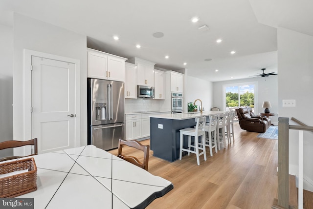 8790 Kensington Church St, Manassas, VA 20112 - kitchen featuring stainless steel appliances, white cabinets, tasteful backsplash, an island with sink, and recessed lighting
