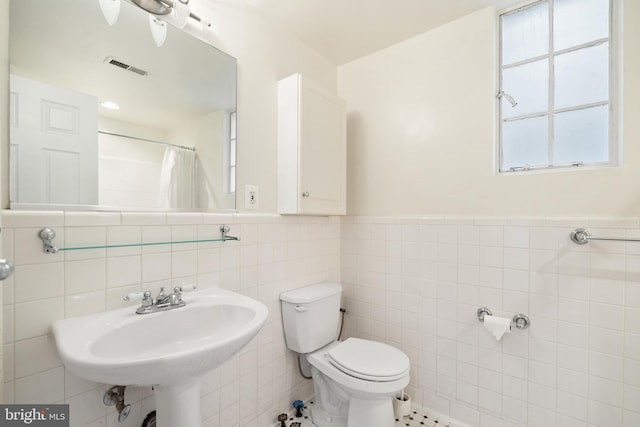 3901 Connecticut Ave NW Unit 406, Washington, DC 20008 - bathroom featuring tile walls, toilet, a sink, a wainscoted wall, and curtained shower