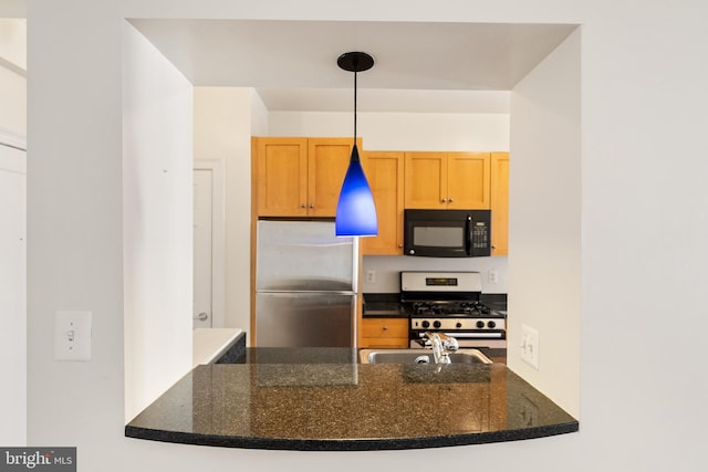 3901 Connecticut Ave NW Unit 406, Washington, DC 20008 - kitchen featuring appliances with stainless steel finishes, a sink, a peninsula, and dark stone countertops