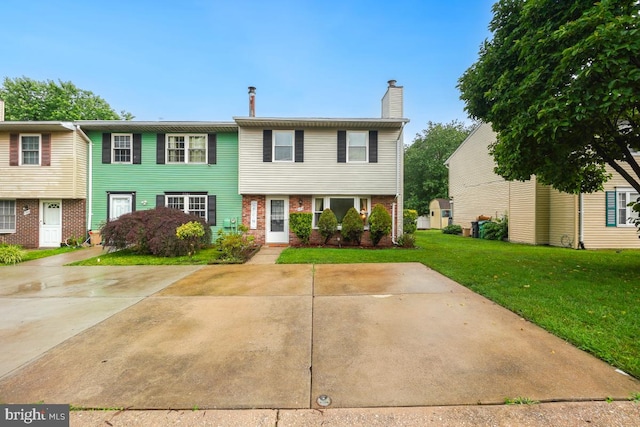7719 Haines Ct, Laurel, MD 20707 - townhome / multi-family property featuring brick siding, a front lawn, and a chimney