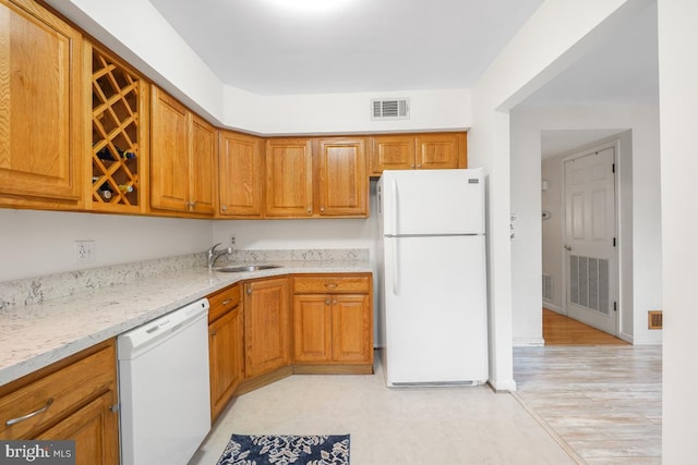7719 Haines Ct, Laurel, MD 20707 - kitchen featuring white appliances, brown cabinets, light stone counters, and light flooring