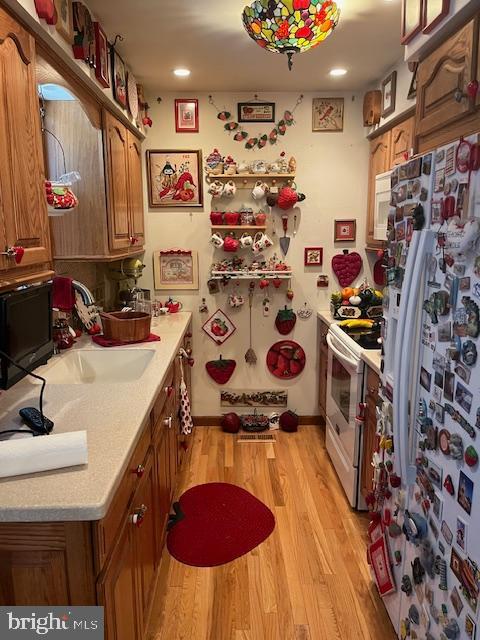 46 Carriage Stop Pl, Florence, NJ 08518 - kitchen featuring white appliances, light wood-style floors, brown cabinets, and recessed lighting