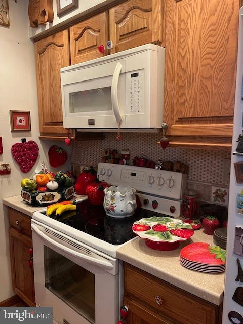 46 Carriage Stop Pl, Florence, NJ 08518 - kitchen featuring white appliances, decorative backsplash, light countertops, and brown cabinets