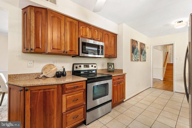 201 Mowbray Rd, Silver Spring, MD 20904 - kitchen featuring stainless steel appliances, brown cabinetry, light tile patterned floors, and baseboards