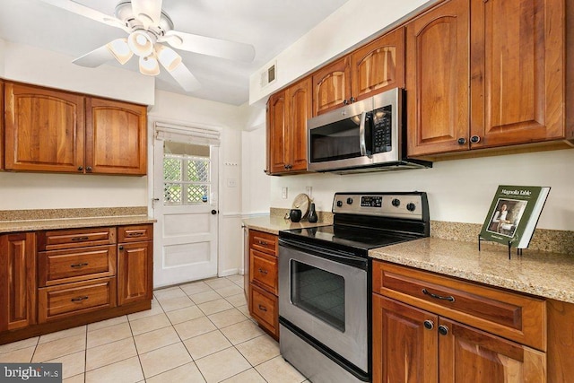 201 Mowbray Rd, Silver Spring, MD 20904 - kitchen with stainless steel appliances, brown cabinets, a ceiling fan, light tile patterned flooring, and light stone countertops