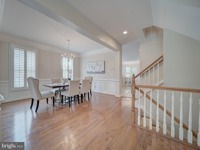 8320 Dockray Ct, Lorton, VA 22079 - dining area featuring a chandelier, plenty of natural light, a decorative wall, light wood-type flooring, and wainscoting