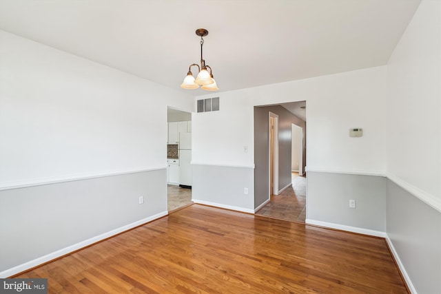 9523 Greencastle Ln, Lorton, VA 22079 - unfurnished room featuring a chandelier, light wood-style flooring, and baseboards