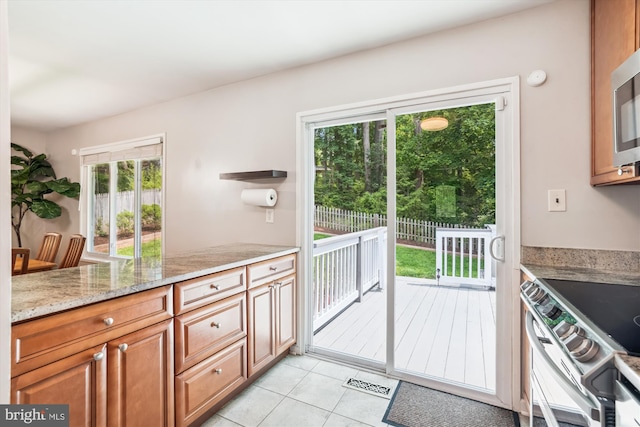 10105 Meredith Ave, Silver Spring, MD 20910 - kitchen featuring stainless steel range with electric stovetop, light tile patterned floors, plenty of natural light, and light stone counters