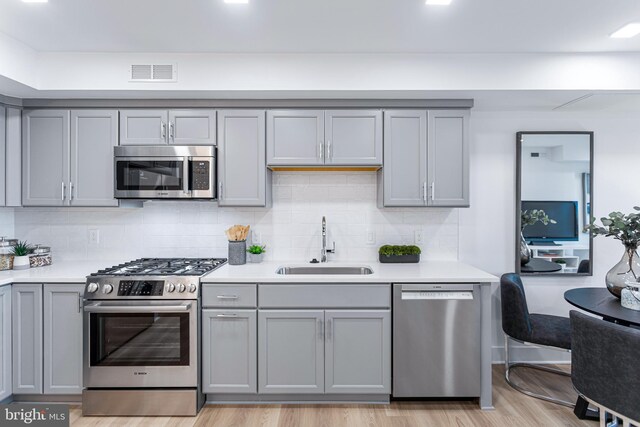 701 N Henry St Unit 212, Alexandria, VA 22314 - kitchen featuring appliances with stainless steel finishes, gray cabinetry, a sink, and light countertops