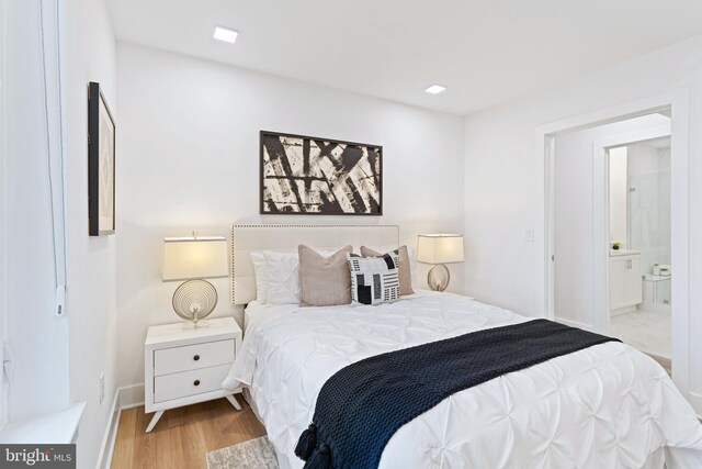 701 N Henry St Unit 212, Alexandria, VA 22314 - bedroom with wood finished floors, baseboards, and ensuite bathroom