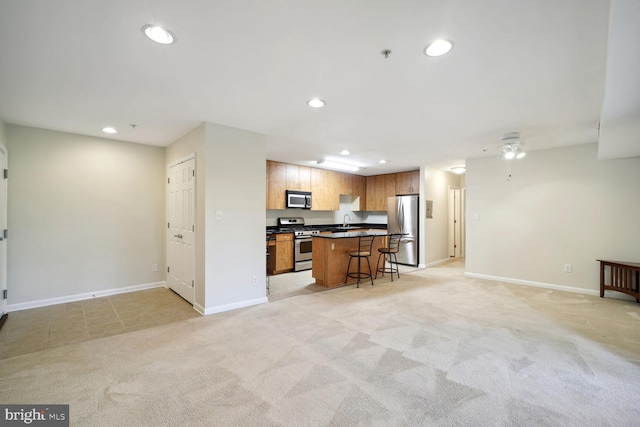 1117 Primrose Ct Unit 304, Annapolis, MD 21403 - kitchen featuring stainless steel appliances, open floor plan, a sink, a breakfast bar, and baseboards