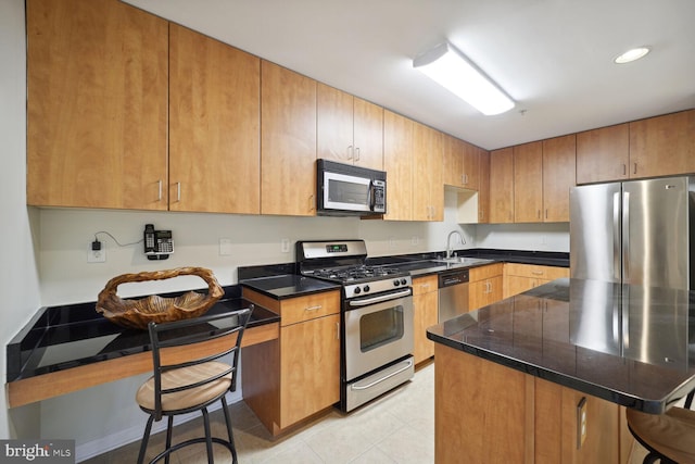 1117 Primrose Ct Unit 304, Annapolis, MD 21403 - kitchen with appliances with stainless steel finishes, a kitchen bar, a sink, tile countertops, and recessed lighting