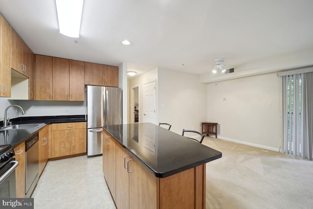 1117 Primrose Ct Unit 304, Annapolis, MD 21403 - kitchen with appliances with stainless steel finishes, a sink, dark countertops, a kitchen island, and brown cabinets