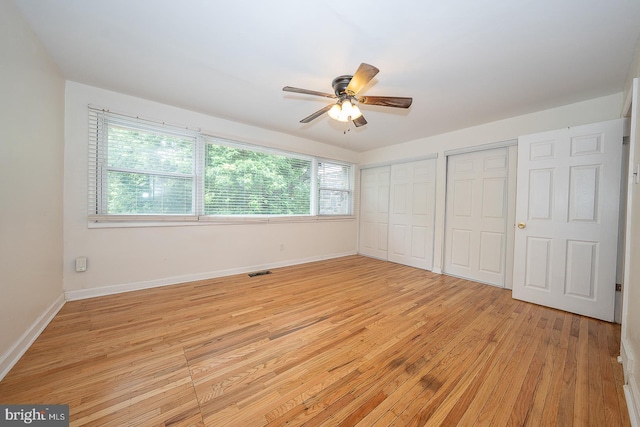 3852 Conshohocken Ave, Philadelphia, PA 19131 - unfurnished bedroom featuring multiple closets, multiple windows, light wood-style flooring, and baseboards