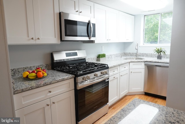 3700 N Rosser St Unit 104, Alexandria, VA 22311 - kitchen with stainless steel appliances, light wood finished floors, white cabinetry, and light stone countertops
