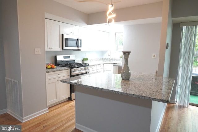 3700 N Rosser St Unit 104, Alexandria, VA 22311 - kitchen with appliances with stainless steel finishes, light wood finished floors, light stone countertops, and white cabinetry