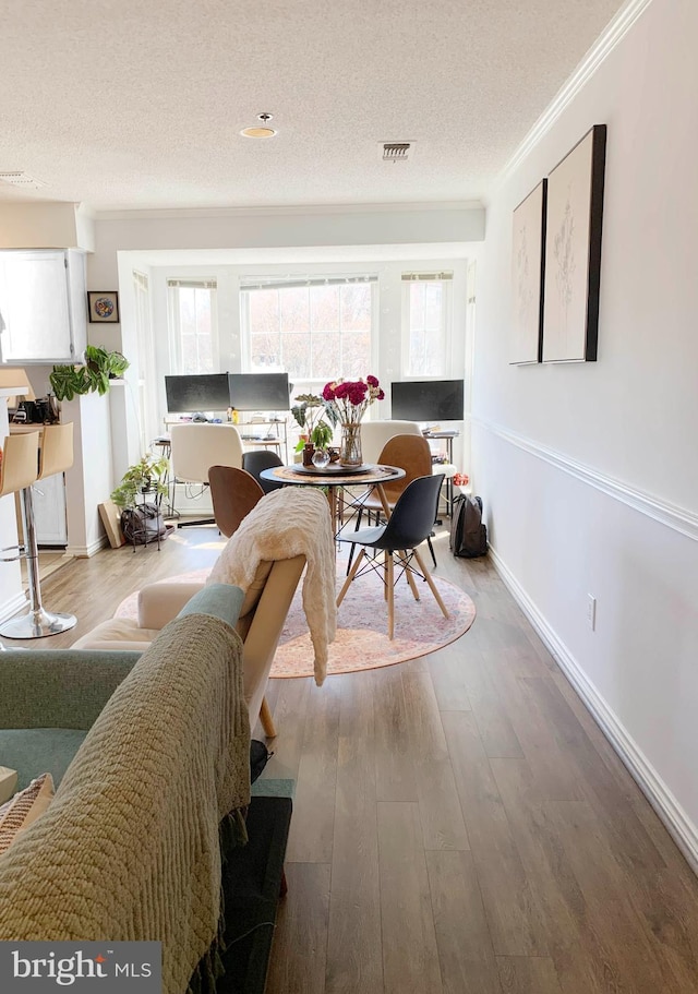 1504 Lincoln Way Unit 305, Mclean, VA 22102 - dining space featuring a textured ceiling, wood finished floors, crown molding, and baseboards