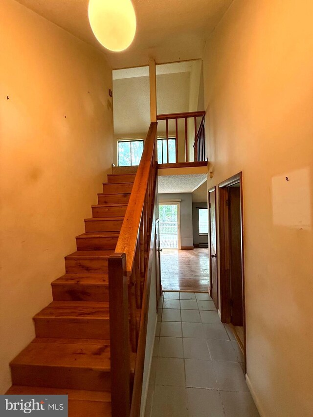 28 Myrtle Dr, Gerrardstown, WV 25420 - stairs featuring a high ceiling, tile patterned floors, and baseboards
