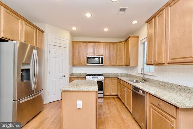 9573 5th Pl, Lorton, VA 22079 - kitchen featuring appliances with stainless steel finishes, a kitchen island, backsplash, light wood-type flooring, and recessed lighting