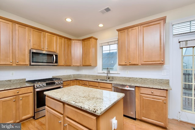 9573 5th Pl, Lorton, VA 22079 - kitchen with appliances with stainless steel finishes, light wood finished floors, a center island, light stone counters, and recessed lighting