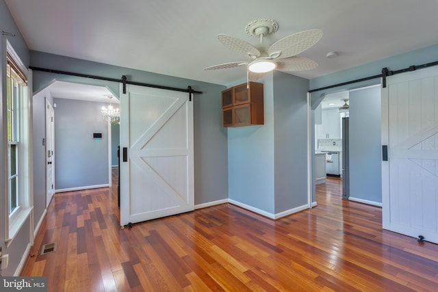4109 Leisure Dr, Temple Hills, MD 20748 - unfurnished bedroom featuring a barn door, wood finished floors, and baseboards