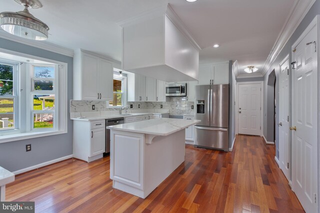 4109 Leisure Dr, Temple Hills, MD 20748 - kitchen with appliances with stainless steel finishes, ornamental molding, dark wood-style flooring, decorative backsplash, and white cabinets