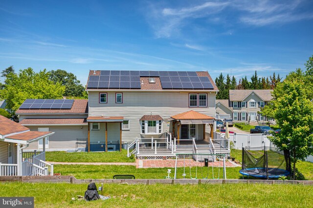 4109 Leisure Dr, Temple Hills, MD 20748 - rear view of house featuring solar panels, a deck, and a trampoline