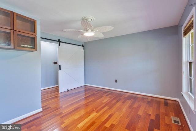 4109 Leisure Dr, Temple Hills, MD 20748 - spare room with a barn door, baseboards, wood finished floors, and a ceiling fan