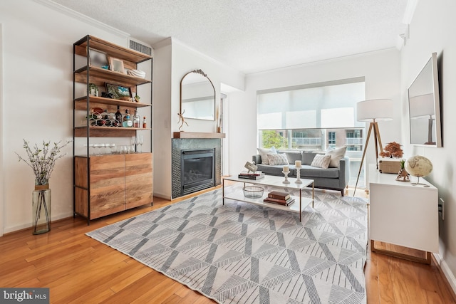 3101 N Hampton Dr Unit 314, Alexandria, VA 22302 - living area featuring ornamental molding, light wood-type flooring, a fireplace, a textured ceiling, and baseboards