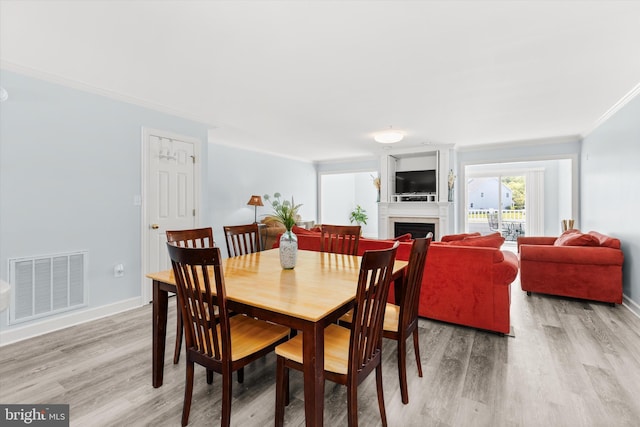 9729 Village Ln Unit 9715C, Ocean City, MD 21842 - dining area with ornamental molding, light wood-style floors, a fireplace, and baseboards