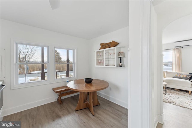 6156 Drum Point Rd, Deale, MD 20751 - dining room featuring light wood finished floors, healthy amount of natural light, baseboards, and arched walkways