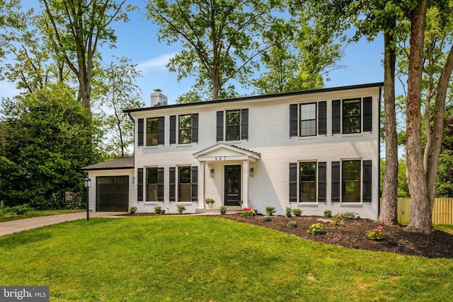 427 W St NW, Vienna, VA 22180 - colonial home with a garage, a chimney, concrete driveway, and brick siding