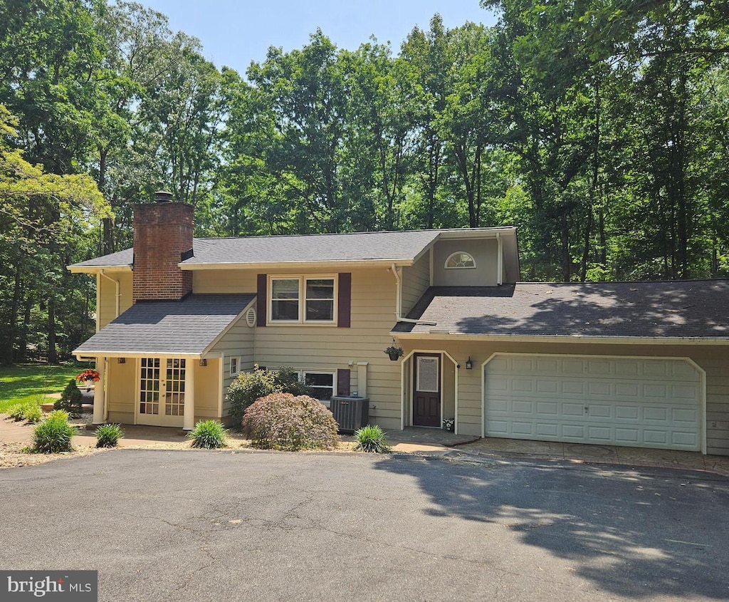 8328 River Rd, Fredericksburg, VA 22407 - view of front of property featuring french doors, driveway, a chimney, a garage, and roof with shingles