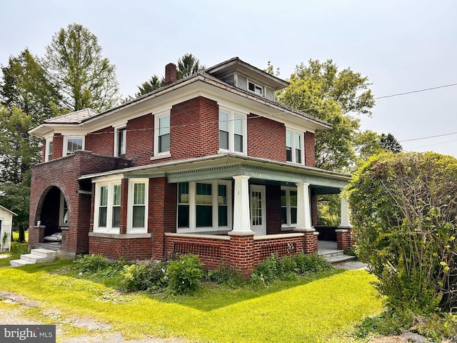 149 W Main St, Millheim, PA 16854 - view of front of home with a porch, brick siding, a chimney, and a front lawn