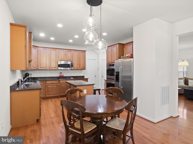 3903 Beeker Mill Pl, Chantilly, VA 20151 - kitchen with stainless steel appliances, a kitchen island, light wood-style floors, recessed lighting, and dark stone countertops