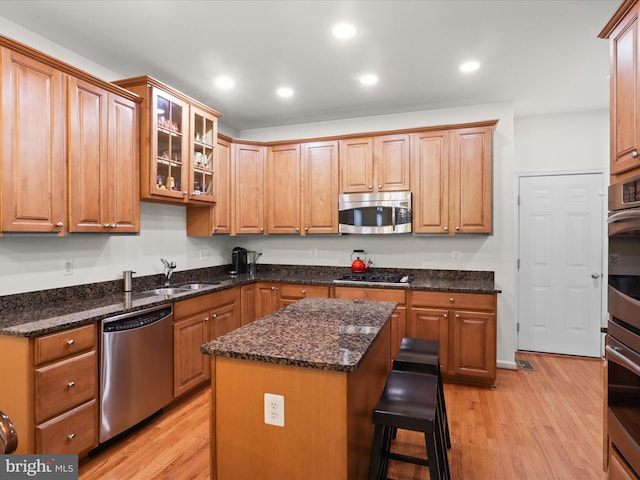 3903 Beeker Mill Pl, Chantilly, VA 20151 - kitchen featuring appliances with stainless steel finishes, light wood finished floors, a breakfast bar, a kitchen island, and recessed lighting