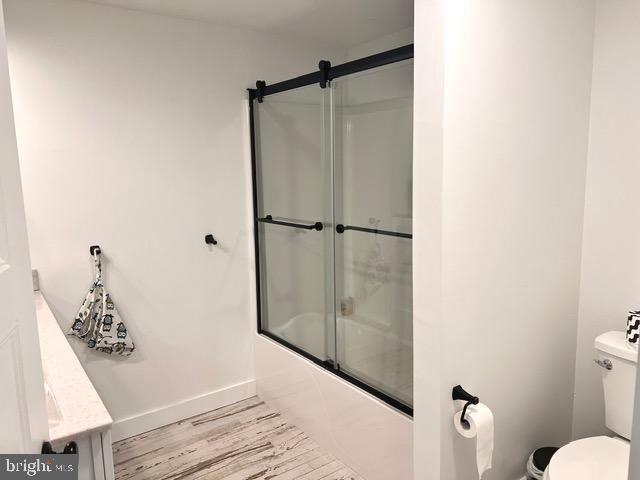 7299 Marshall St, Lincoln, DE 19960 - bathroom featuring toilet, combined bath / shower with glass door, baseboards, vanity, and wood finished floors