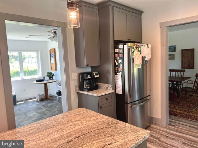 7299 Marshall St, Lincoln, DE 19960 - kitchen featuring freestanding refrigerator, gray cabinets, ceiling fan, pendant lighting, and wood finished floors