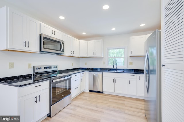 2968 Sulphur Springs Rd, Inwood, WV 25428 - kitchen with appliances with stainless steel finishes, white cabinets, recessed lighting, light wood-style floors, and dark stone countertops