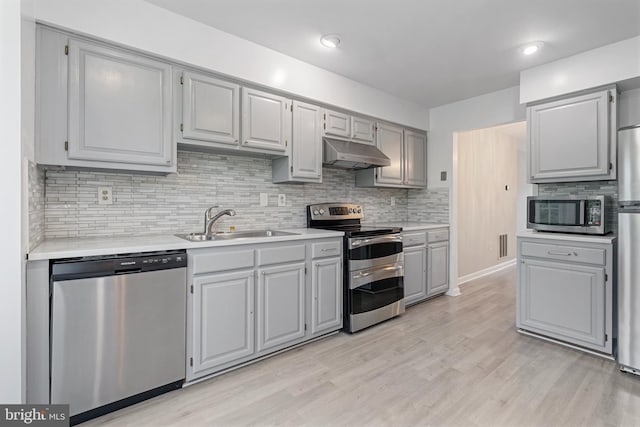 12307 Sandy Point Ct, Silver Spring, MD 20904 - kitchen featuring appliances with stainless steel finishes, under cabinet range hood, gray cabinets, light countertops, and tasteful backsplash